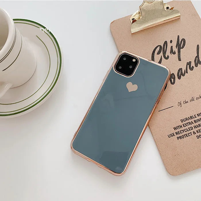Solid colour TPU back cover case for iPhone on a table, shown in blue, claret, pink, and green.