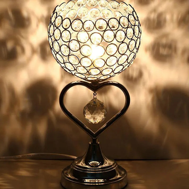 Modern minimalist crystal USB table lamp with heart-shaped design on a bedside table