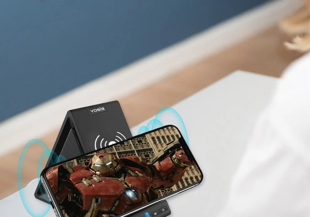Black multifunctional Bluetooth speaker with integrated phone stand and wireless charging pad, showing size scale.