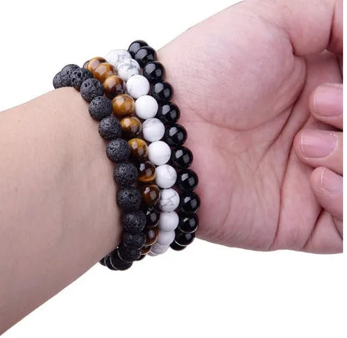 Black agate bracelet with geometric 8mm beads on a black elastic cord, laid flat.