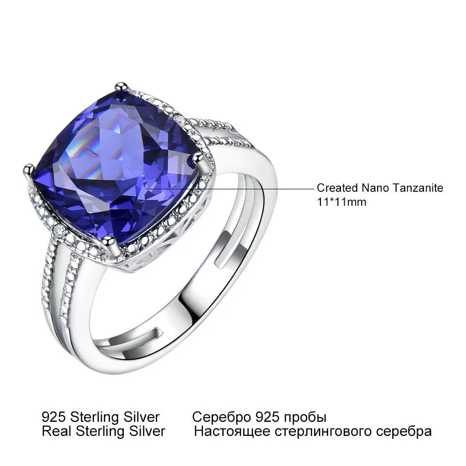 A sterling silver ring for women with a bright blue tanzanite stone, shown on a hand.