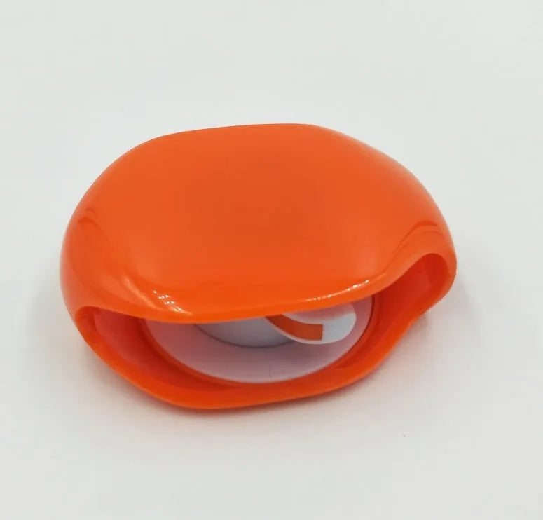 Automatic earphone cable winder retractor in blue, showing compact size next to a 3.5mm jack.