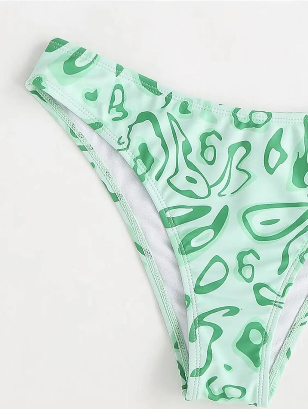 Green floral bandeau bikini swimsuit with split design and adjustable straps on mannequin