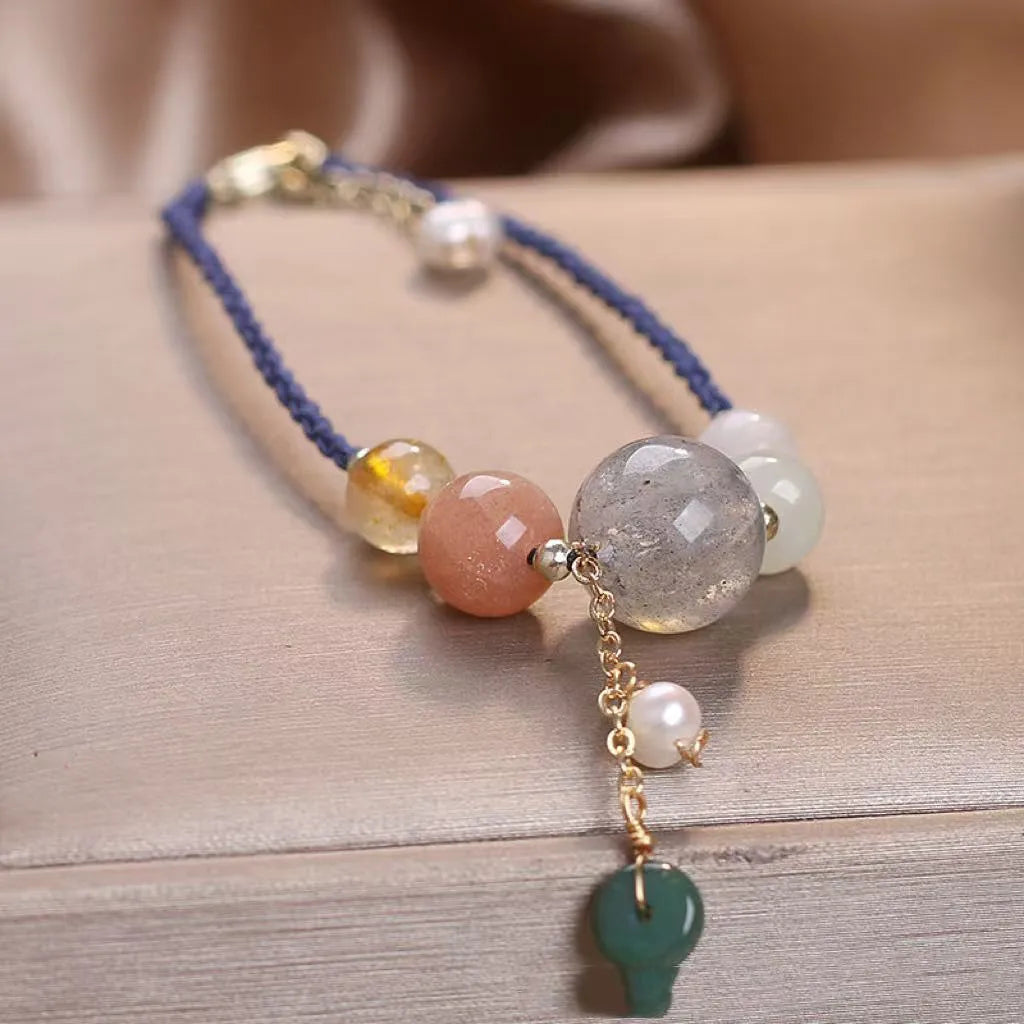 Women's hand-woven bracelet with crystal and sequins on a peace buckle clasp, shown in red, green, and blue colours.