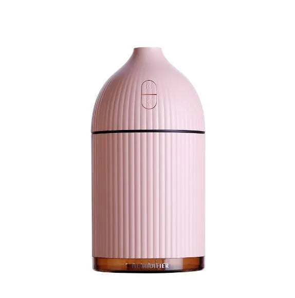 White USB aromatherapy diffuser and humidifier with LED light on a wooden desk