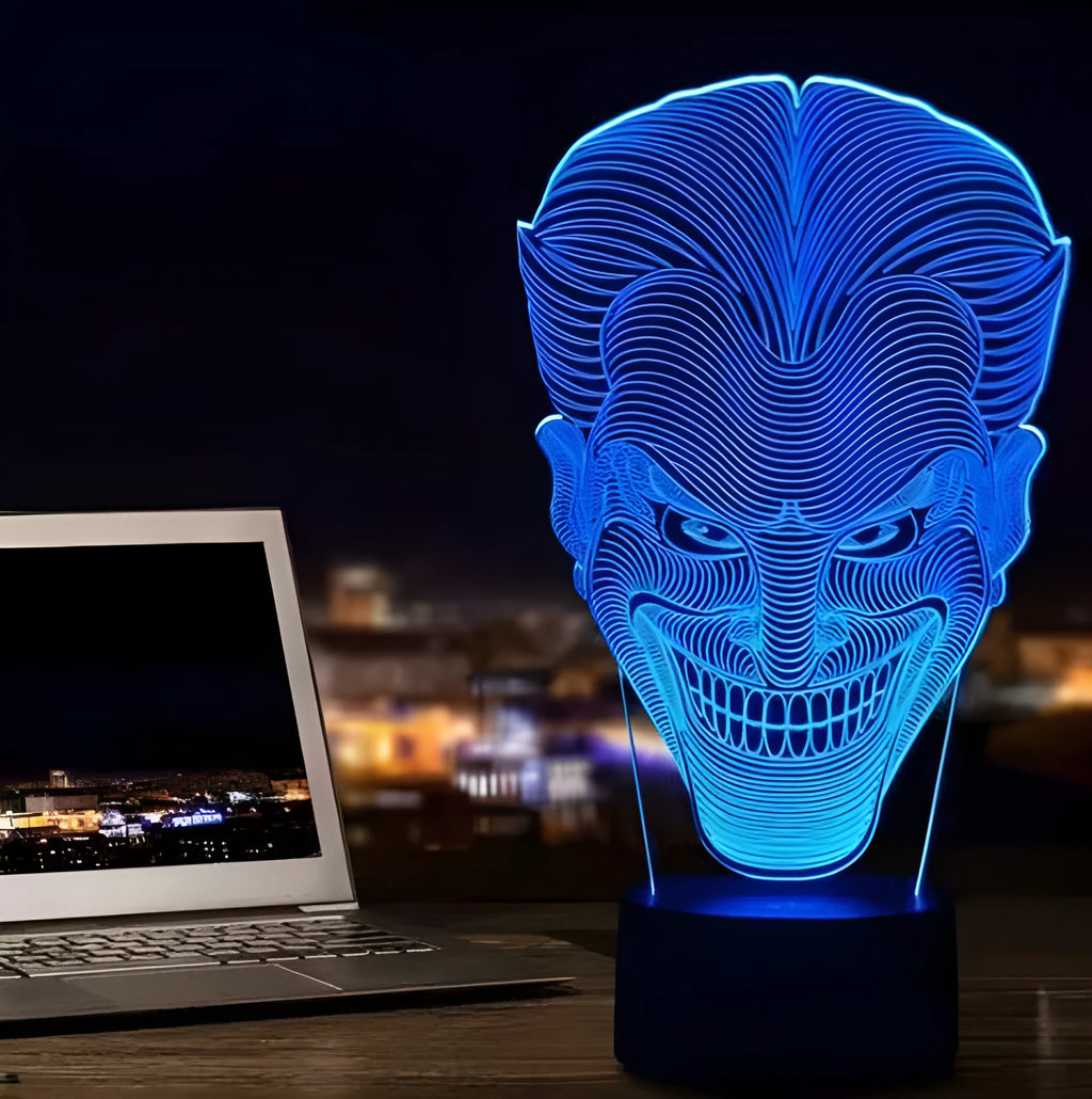 A 3D acrylic LED lamp on a base, showing a colourful gradient light effect, with a remote control beside it.