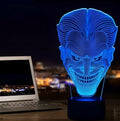 A 3D acrylic LED lamp on a base, showing a colourful gradient light effect, with a remote control beside it.