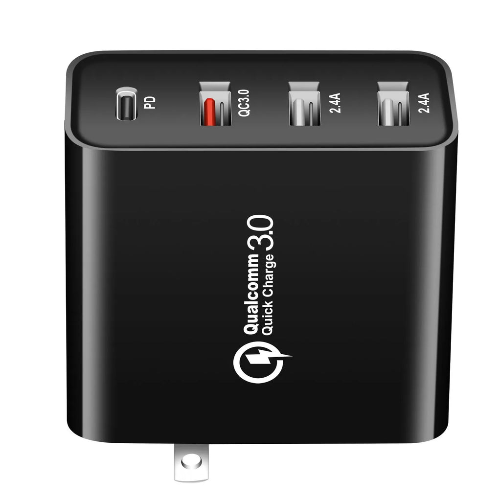 Black 48W desktop charger with four USB-C ports and a white UK plug on a wooden table.