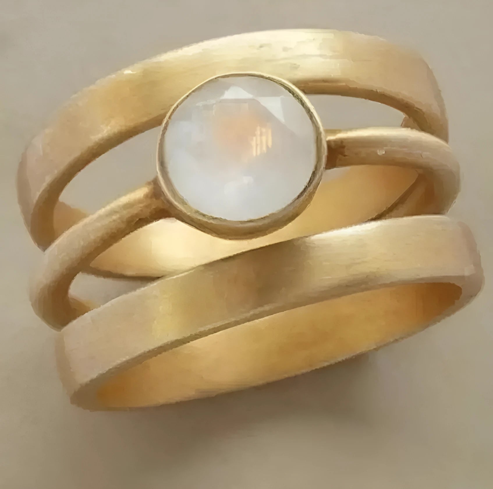 A gold-plated geometric ring with a hollow micro-inlaid white chalcedony stone on a titanium steel band.