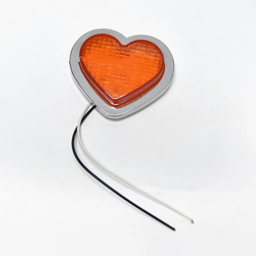 Heart-shaped red LED car fender sidelight on a black background.