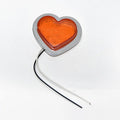 Heart-shaped red LED car fender sidelight on a black background.