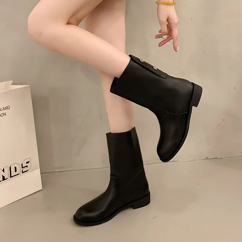 Women's black leather mid-calf platform boots with silver stud details on a white background