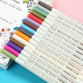 Black plastic card album with coloured metal pens arranged on a white background for office stationery use.