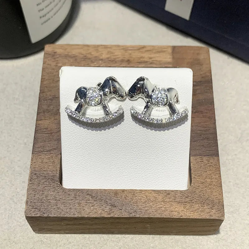 Diamond studded rocking horse earrings in gold and silvery metal finish for women