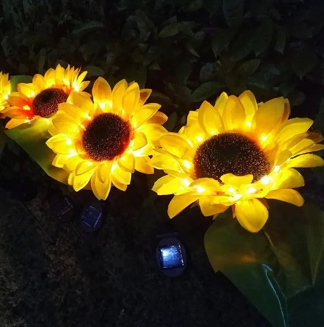 LED solar sunflower lamp with yellow fabric flower head, 66cm stainless steel stem, and ABS ground plug, placed on grass