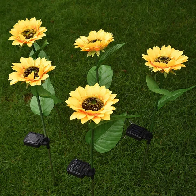 LED solar sunflower lamp with yellow fabric flower head, 66cm stainless steel stem, and ABS ground plug, placed on grass