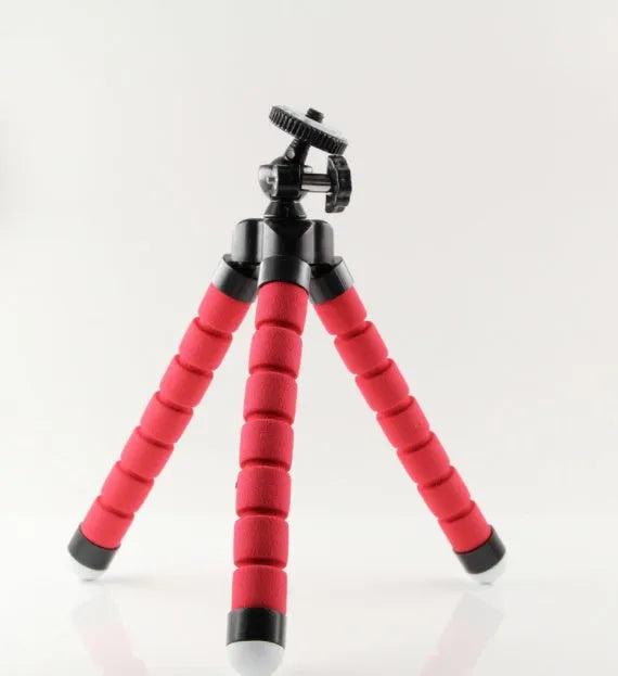 Black flexible octopus tripod with wrapped legs holding a smartphone next to a camera.