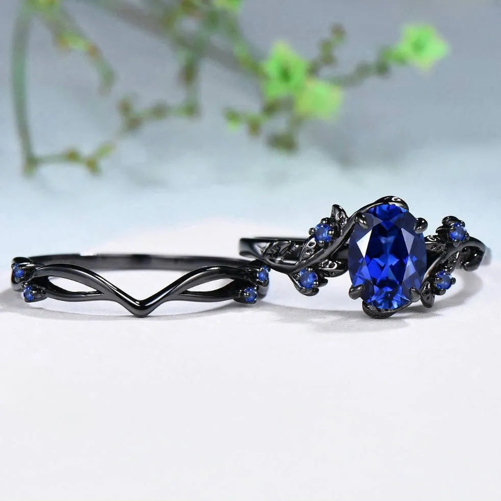 Geometric gun black couple ring for women with a single inlaid navy blue rhinestone.