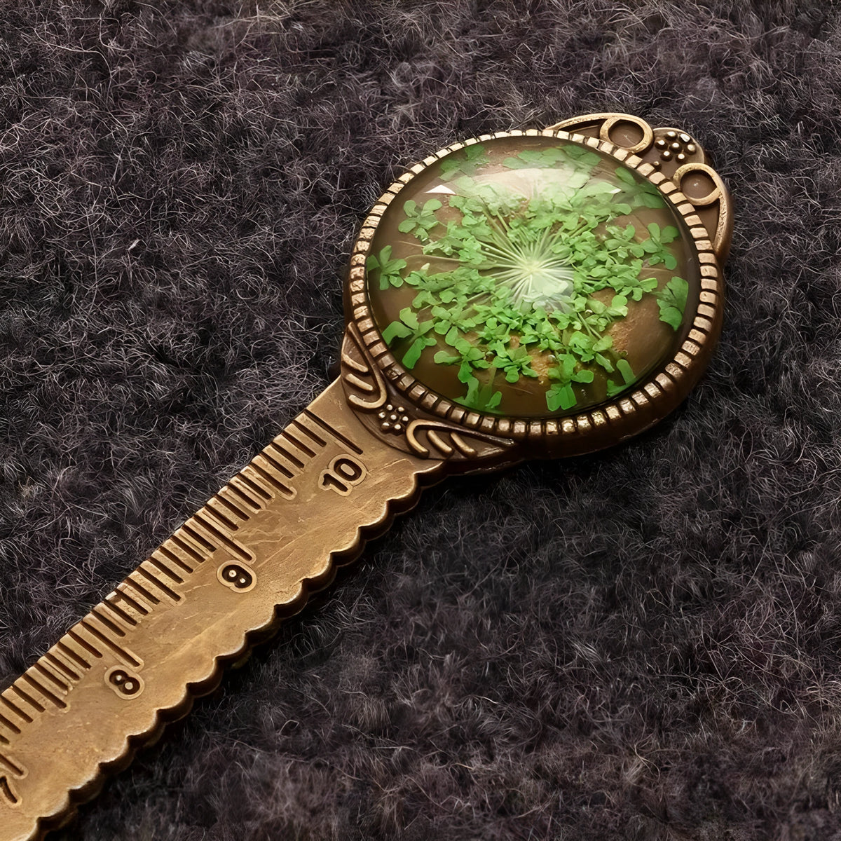 Handmade dried gypsophila and clover flower bookmark ruler on a book, showing 12cm length.
