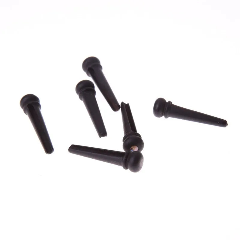 Six matt black ebony wood guitar string nails for folk acoustic guitars.