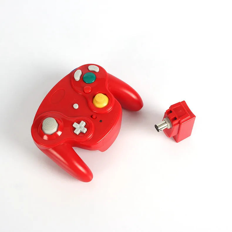 NGC wireless game controller in multiple colours on a grey background, showing its compact size and button layout.