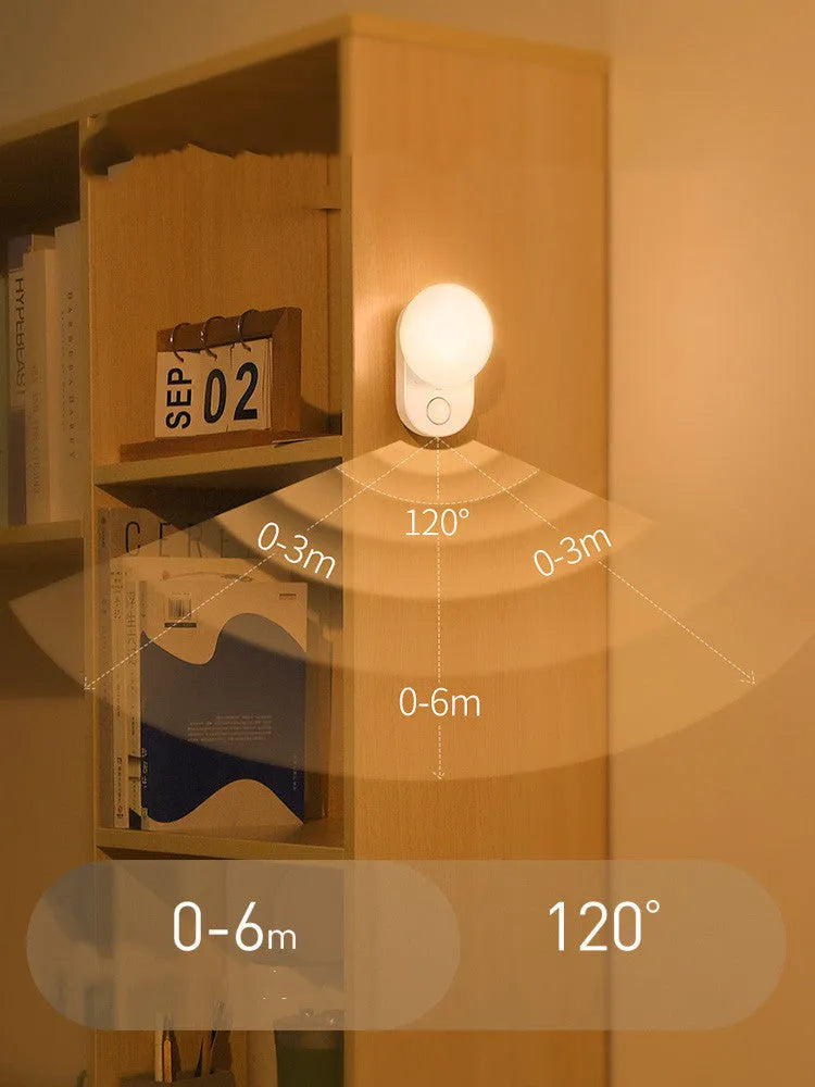 White Baseus rechargeable night light with motion sensor on a wooden bedside table.