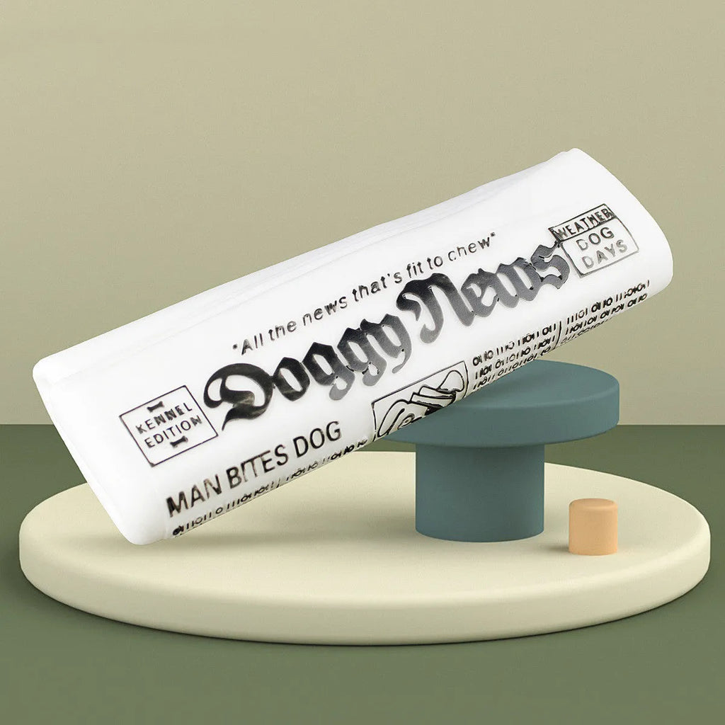 Squeaky black and white PVC dog toy shaped like a rolled newspaper on a surface