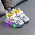 Kids' black light-up sneakers with mesh panels, Velcro strap, and glowing LED lights in the sole.