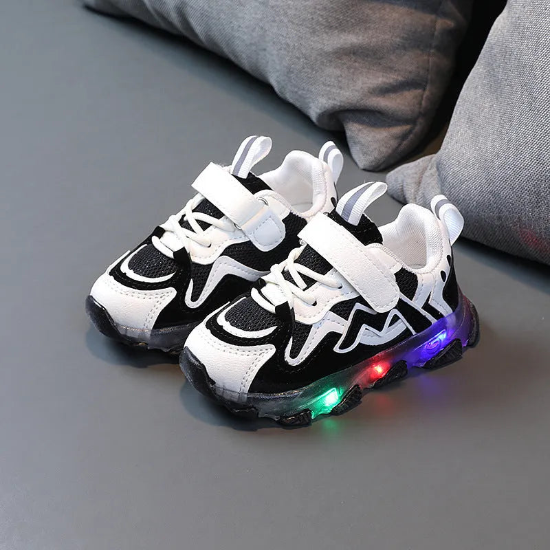 Kids' black light-up sneakers with mesh panels, Velcro strap, and glowing LED lights in the sole.
