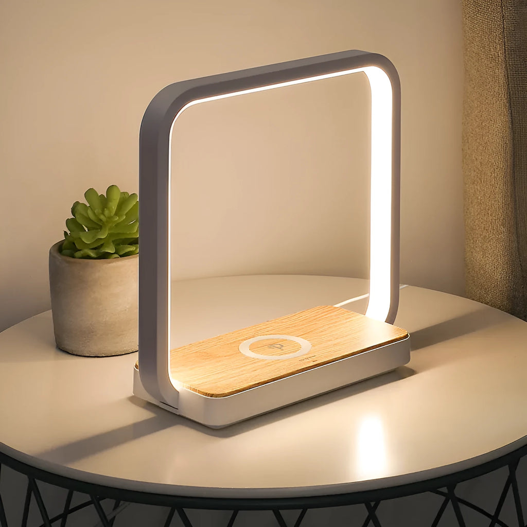 Modern white smart bedside lamp with touch base and USB cable on a wooden nightstand.
