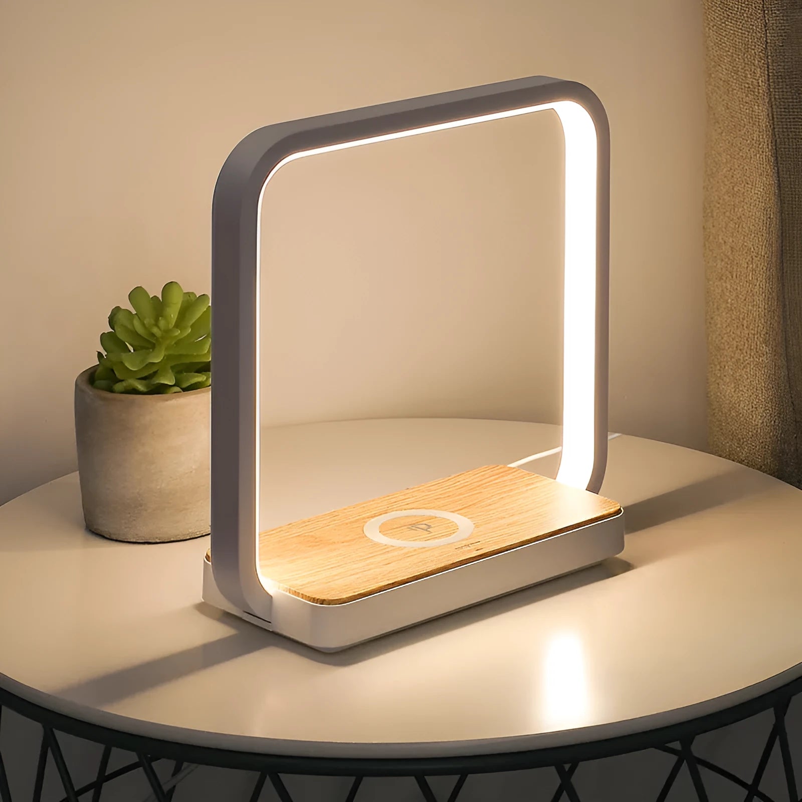 Modern white smart bedside lamp with touch base and USB cable on a wooden nightstand.