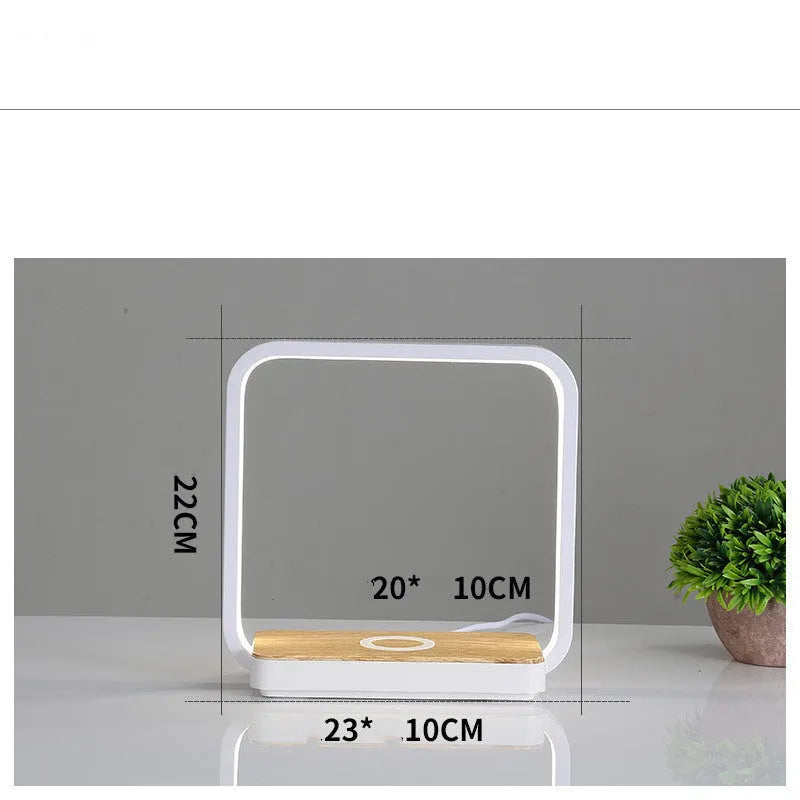 Modern white smart bedside lamp with touch base and USB cable on a wooden nightstand.
