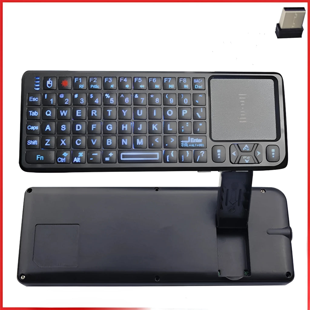 Black wireless mini keyboard with integrated optical mouse and USB receiver on a wooden desk