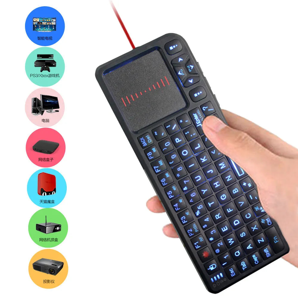 Black wireless mini keyboard with integrated optical mouse and USB receiver on a wooden desk
