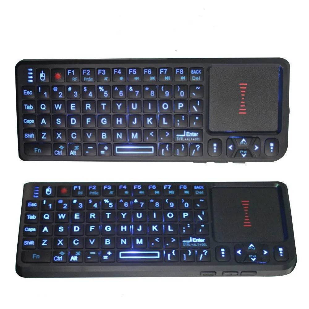 Black wireless mini keyboard with integrated optical mouse and USB receiver on a wooden desk