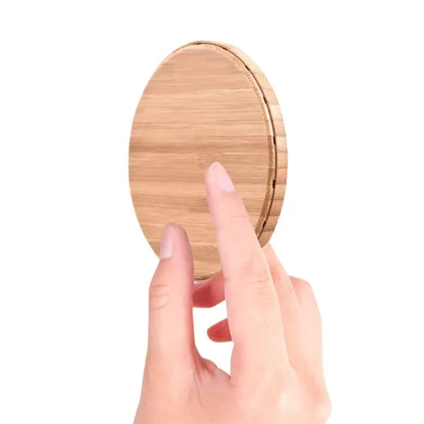 Natural bamboo wireless charger pad on desk with a smartphone placed on it
