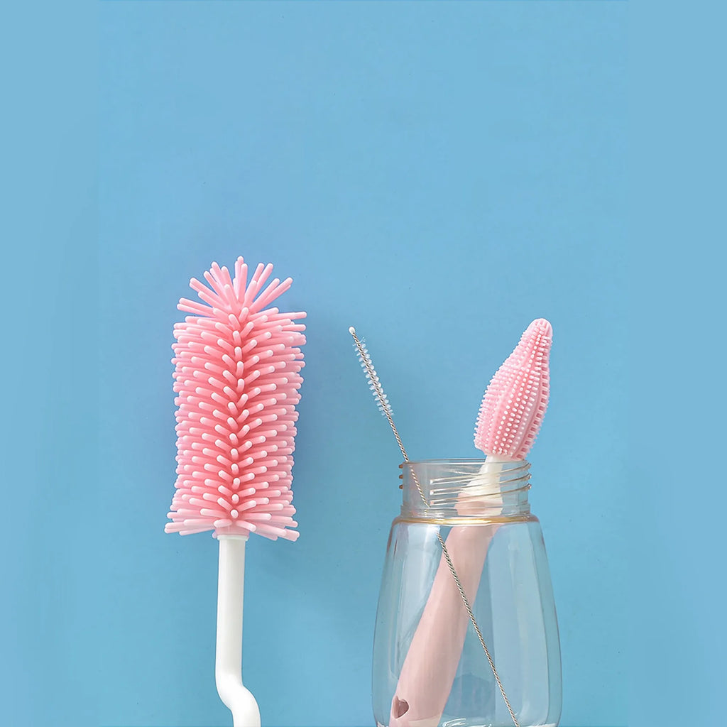Three silicone baby bottle brushes in blue, pink, and yellow with straw scrubber on white background