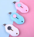 Cartoon styled open box art knife with plastic housing and metal cutting mechanism