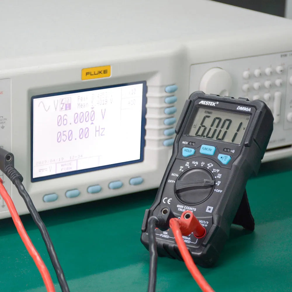 DM90A digital multimeter with test leads on a workbench, showing its display and temperature probe