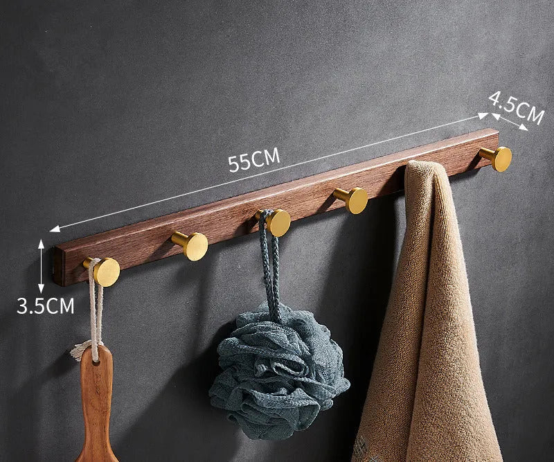Black Walnut and brass-finished aluminium wall-mounted row hooks in a perforated style.