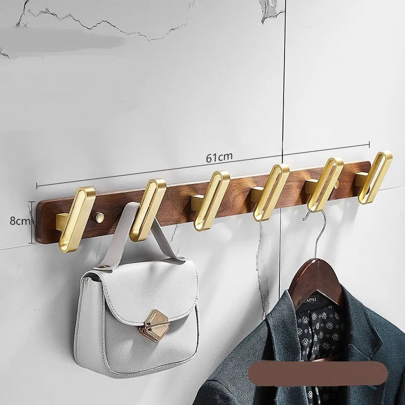 Black Walnut and brass-finished aluminium wall-mounted row hooks in a perforated style.