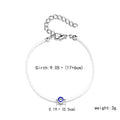 Handmade black string bracelet with evil eye charm and blue beads on a white background