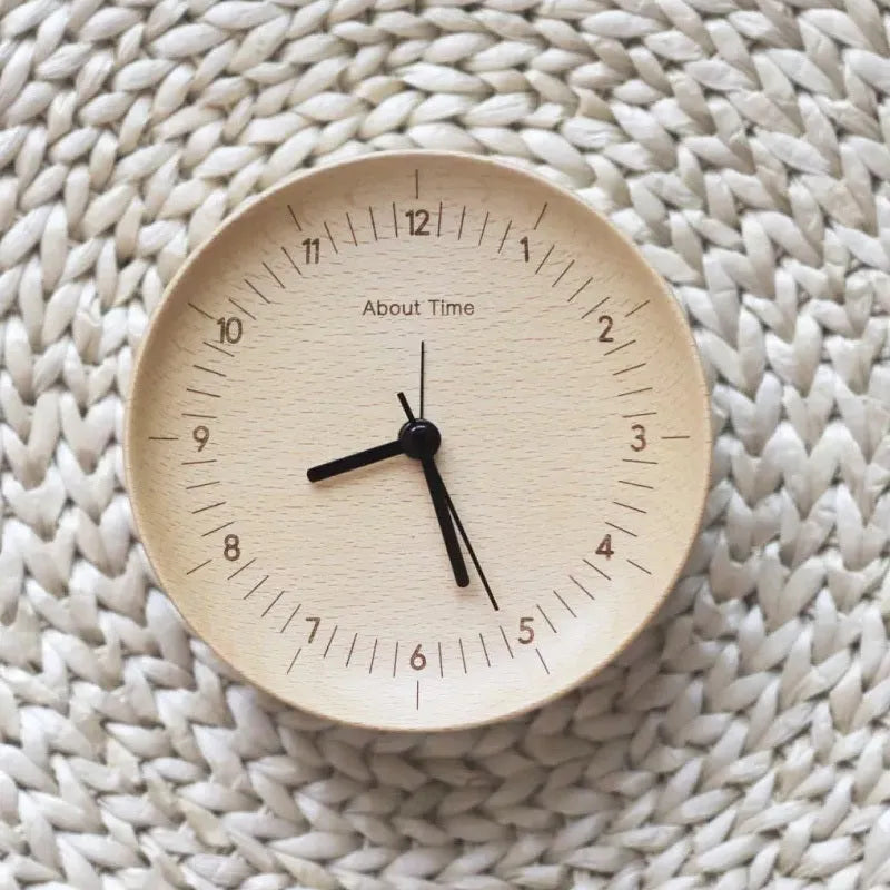 AboutTime log mute pendulum alarm clock in German beech wood, 12cm diameter, featuring Sun brand movement, on a simple desk