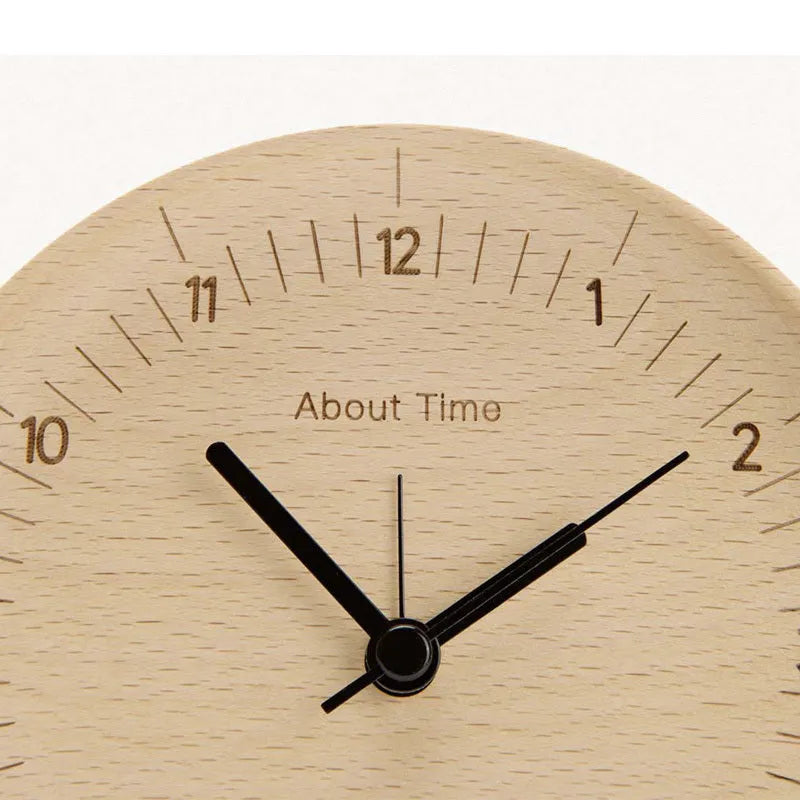 AboutTime log mute pendulum alarm clock in German beech wood, 12cm diameter, featuring Sun brand movement, on a simple desk