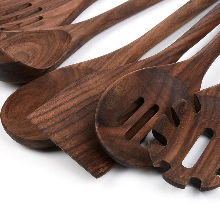 Six-piece black walnut wooden kitchen utensil set with spoon, spatula, slotted spoon and spaghetti claws