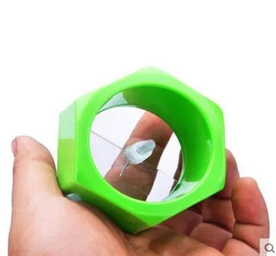 Yellow and green plastic spiral vegetable cutter for slicing cucumbers on a kitchen worktop.