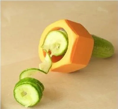 Yellow and green plastic spiral vegetable cutter for slicing cucumbers on a kitchen worktop.
