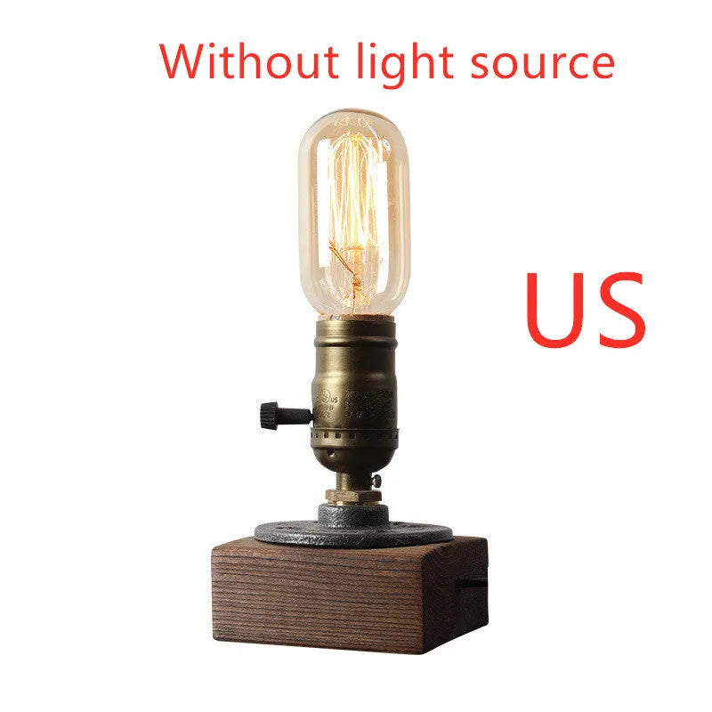 Compact wood and iron water pipe style table lamp on a table.
