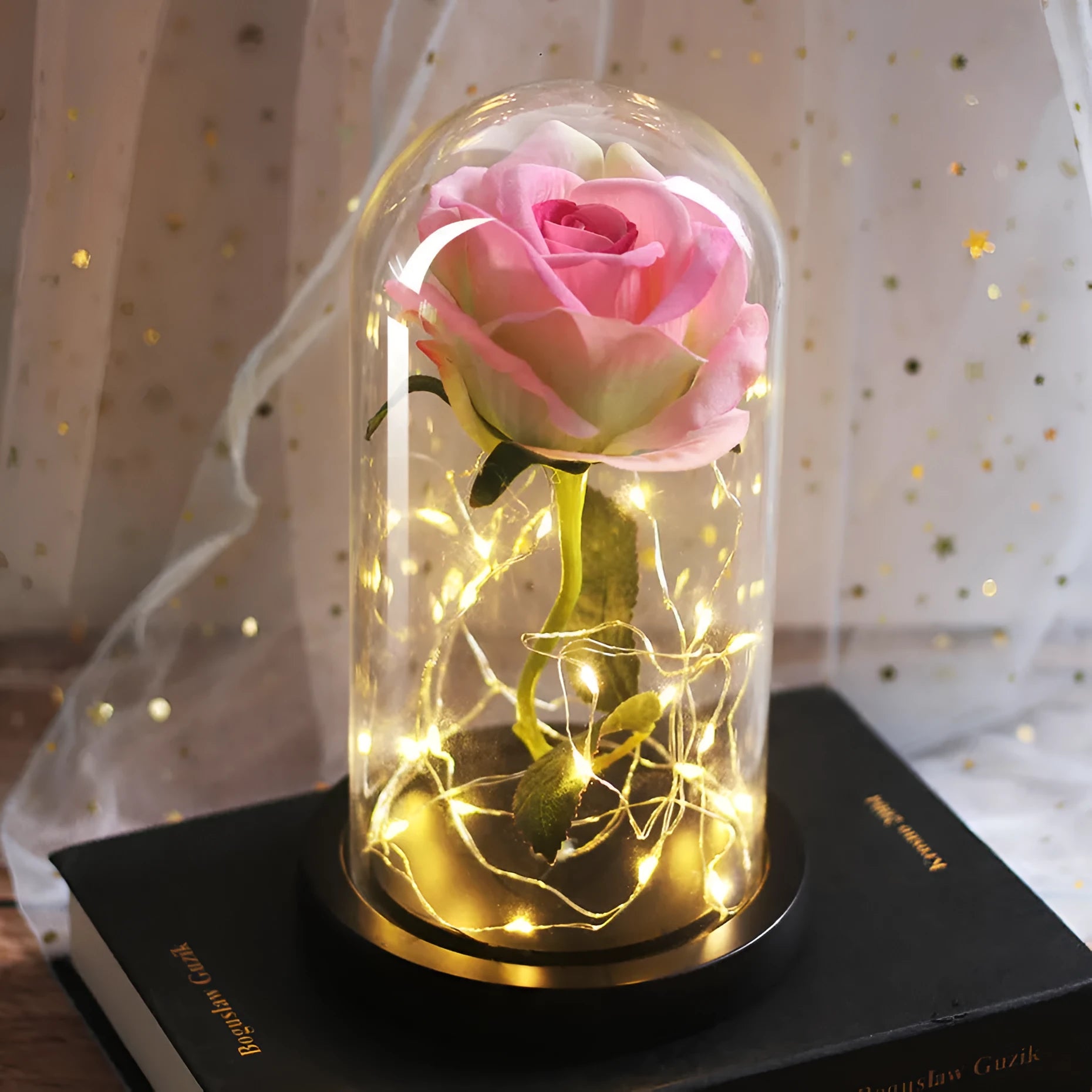 LED rose bouquet with glass lampshade showing warm white lights on simulation silk flowers.
