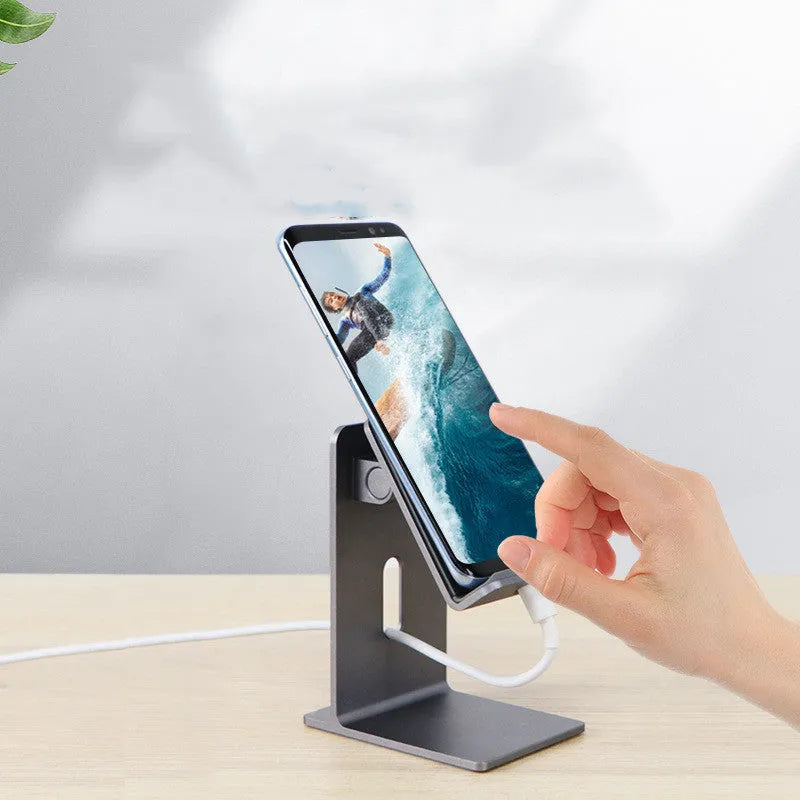 Dark Space Gray alloy mobile phone holder with adjustable arm holding a smartphone on a wooden desk.